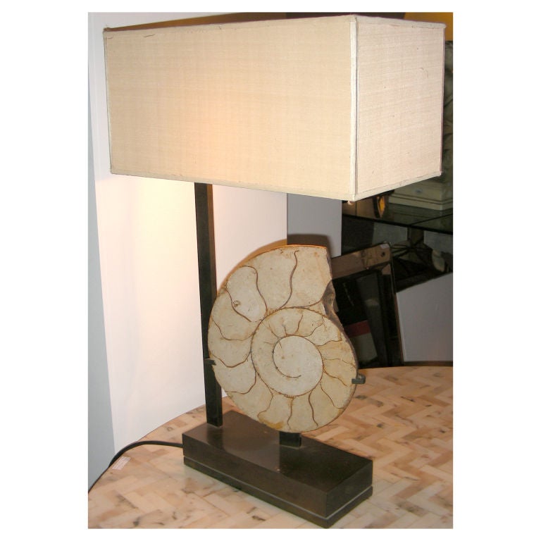 A BRASS LAMP WITH FOSSIL DECORATION