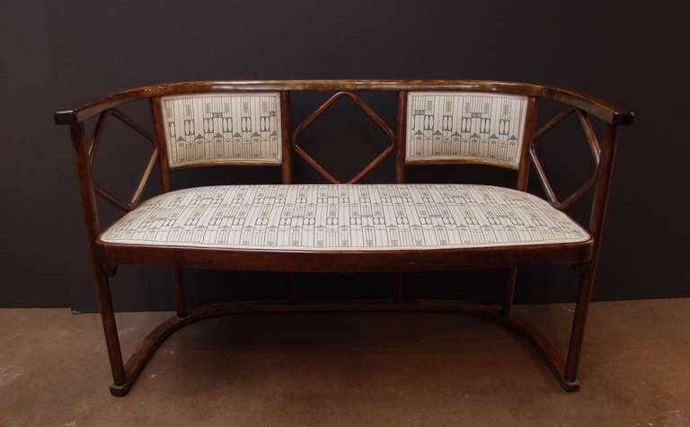 A period Vienna Secession bentwood settee designed by Josef Hoffmann in 1905, and manufactured by Thonet in 1910.

The bentwood construction features simple, clean lines and plenty of negative space. The stained ash wood displays a beautiful grain
