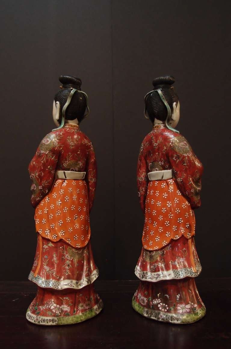 A fine pair of Chinese export porcelain candle holders modeled as court ladies and decorated in famille rose enamels. 

The ladies are portrayed standing, dressed in long, flowing, informal court robes and surcoats, with colorful sashes tied