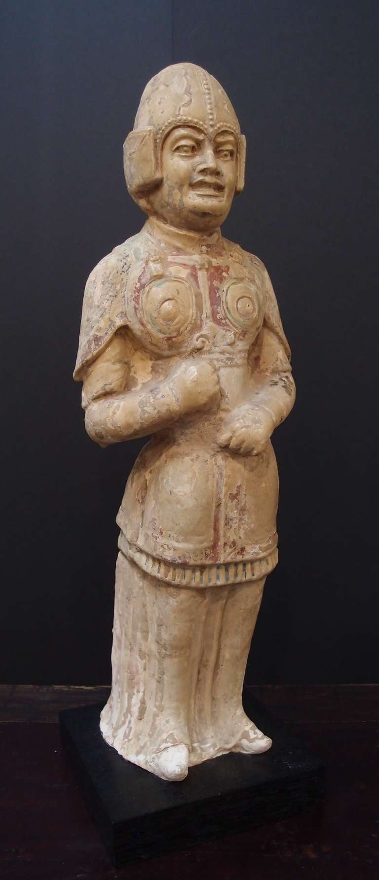 Un très rare modèle de guerrier en poterie peinte et vernie de la dynastie Sui.
Ce guerrier est représenté debout, portant une armure près du corps sur une longue tunique, et il est coiffé d'un couvre-chef clouté et ajusté. Son visage est moulé