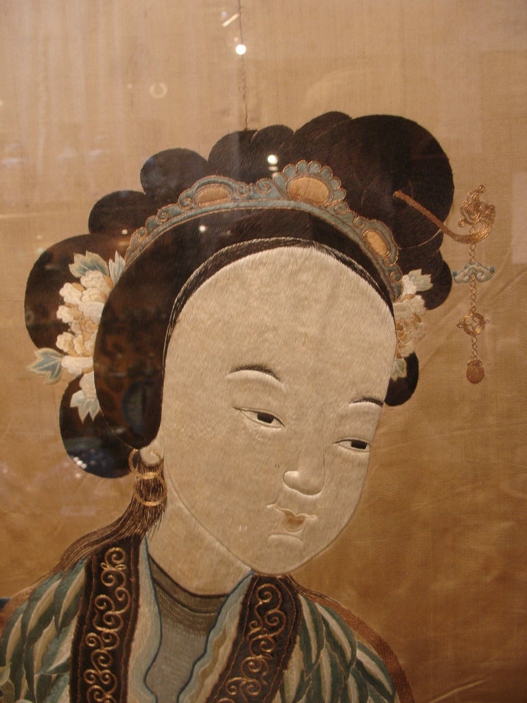 A fine and detailed embroidery depicting the immortal He Xiangu. She is depicted here dressed in elaborate robes, meticulously embroidered with 