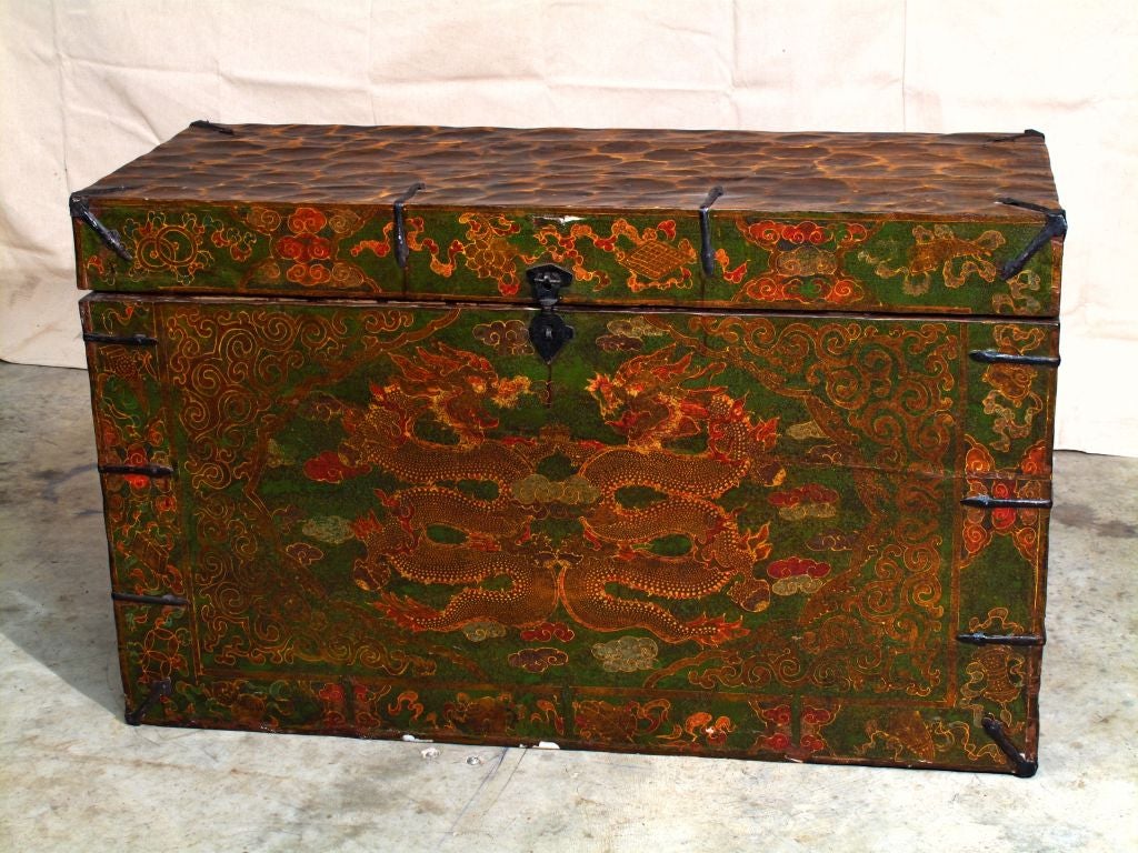 A vibrantly painted Tibetan trunk. The front decorated with polychrome and raised lacquer.
The central image portrays two facing dragons writhing amongst clouds, each clutching a flaming pearl of wisdom. The outer border displays the Ashtamangala,