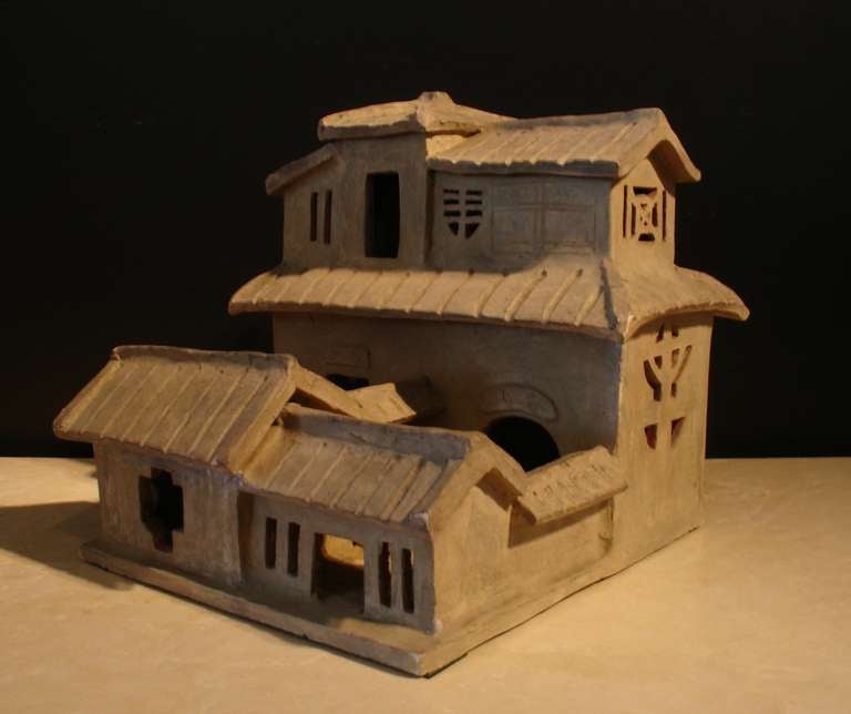 An Eastern Han Dynasty model of a two story courtyard home. The exterior walls enclose the main courtyard. Two halls occupy the ground level. Interestingly, the hall on the right is named 