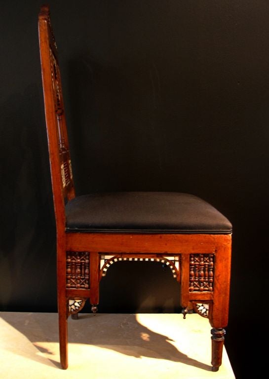 A highly architectural pair of Moroccan side chairs.<br />
<br />
With echoes of sweeping Moorish architecture, the back features a central horseshoe arch flanked on either side by narrower lancet arches. Inlay work or mother of pearl, bone and