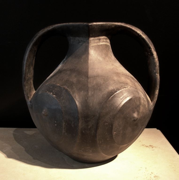 A voluptuous Han Dynasty burnished black pottery amphora.<br />
<br />
The bulbous body features two pair of raised spiral decorations terminating in a protruding nipple on each side. A pair of curvaceous  handles rise from either side of the body
