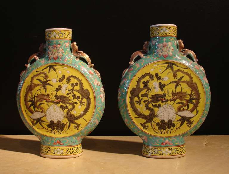 A beautiful pair of Chinese moon flasks. So named because of the flat, round body, which resembles a full moon and based on much earlier pilgrim flasks originally made of leather. 
The bodies painted with a stylized chrysanthemum design in shades