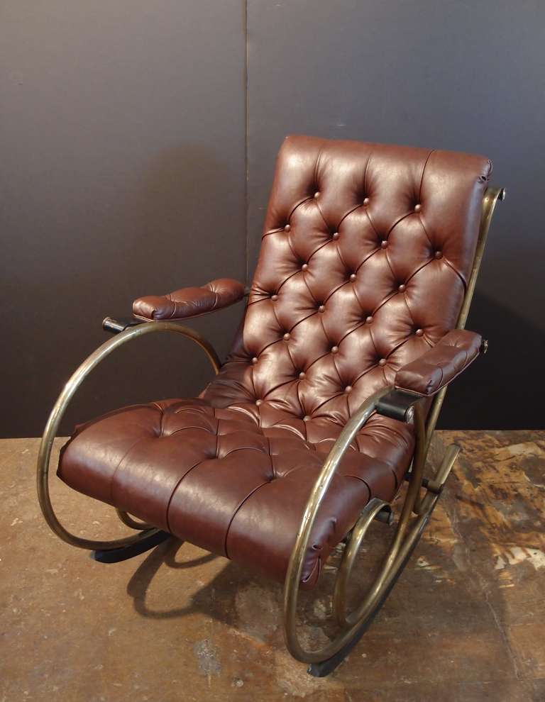 A comfortable, stylish and distinctive rocking chair designed by Lee L. Woodard of the Woodard and Sons company from Owosso, Michigan. The naturally distressed rich brown leather seat brings incredible comfort and a modern feel to the unique vintage
