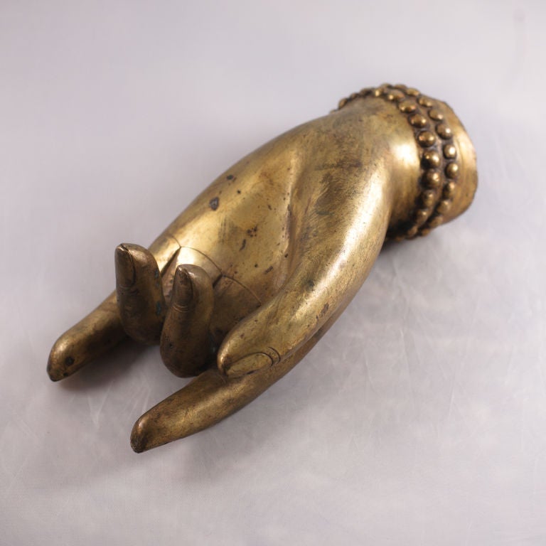 A large and well cast, gilt left hand of a bodhisattva. A fragment from what would have been a larger than life statue, this elegant hand features slightly tapered fingers with a slight natural curve and wonderful detail paid to the fingernails. A