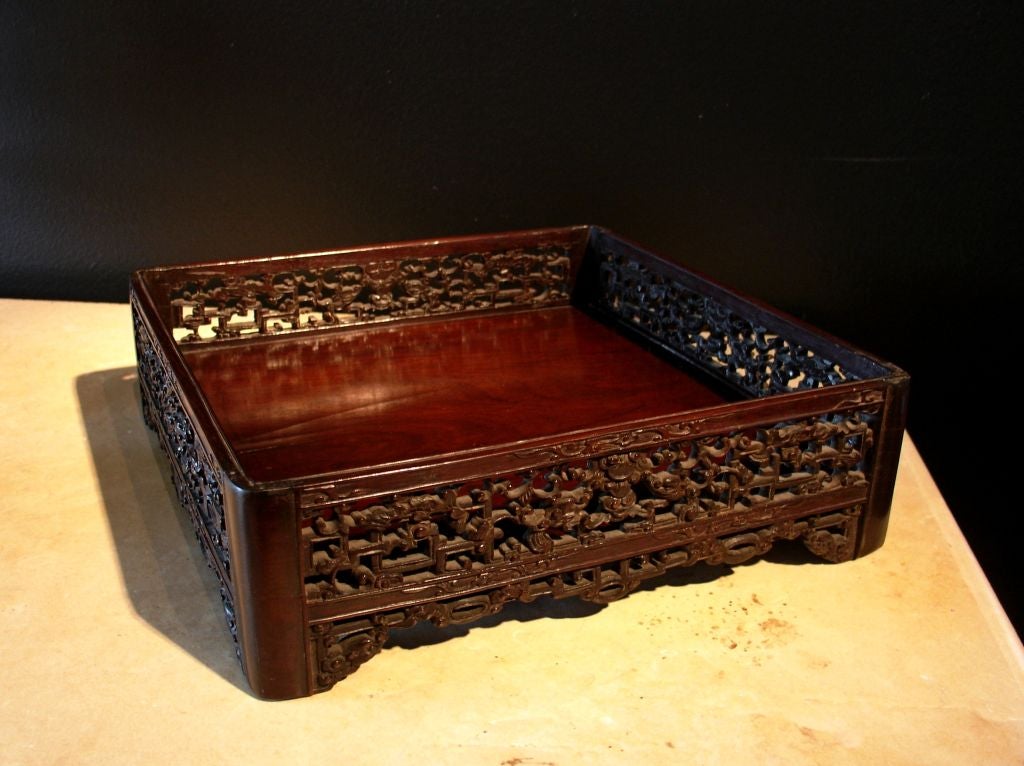 A finely carved and pierced scholar's tray of zitan wood. The intricately carved sides feature a decoration of facing qilin with abstracted, geometric, bodies in the 