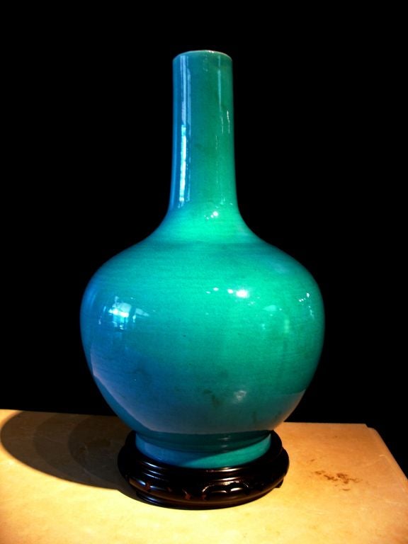 A well potted and brilliantly glazed bottle vase. The globular body is set upon a short foot. An elegant thin neck rises from the slightly bulbous shoulder. <br />
<br />
The vase is glazed in a vivid turquoise, the interior and base glazed in a