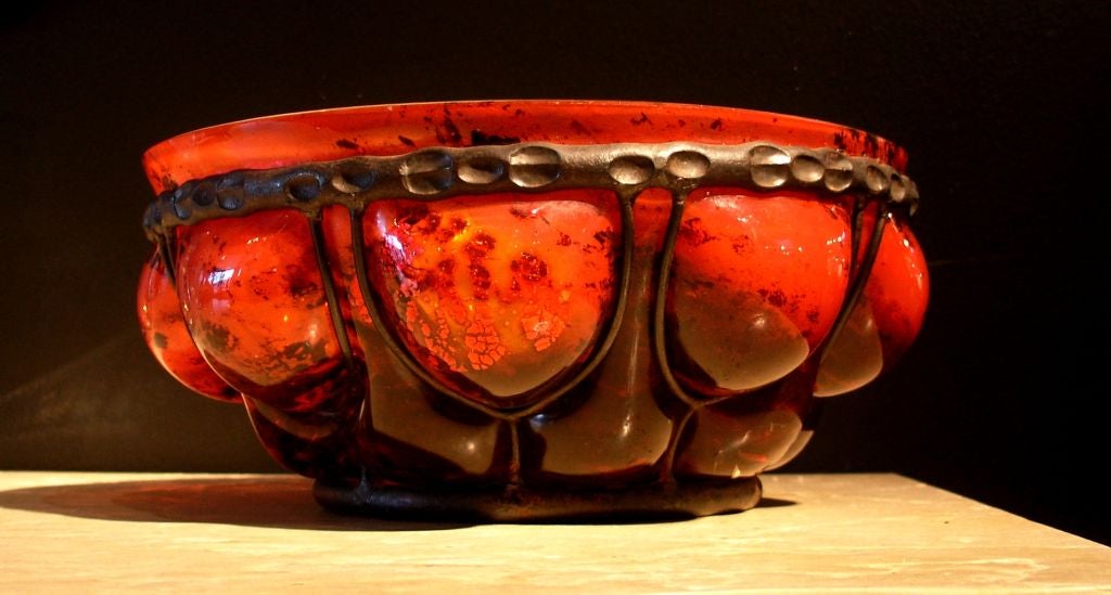 NOTE: THIS ITEM WAS STOLEN FROM OUR GALLERY ON 5/28/2012

A French Art Deco glass and wrought iron bowl by Daum and Majorelle.

Internally decorated glass of sunset orange and blood red, accented by gold foil flecks set within a hand wrought