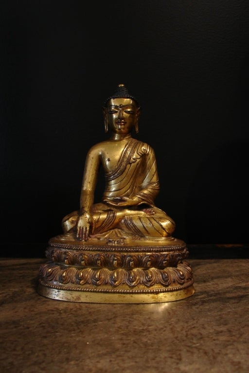 A well cast image of Shakyamuni Buddha, the historical Buddha.<br />
<br />
He is portrayed seated in dhyanasana upon a crisply cast double-lotus base, his hands in bhumisparsamudra (calling the earth to witness), with a raised vajra before him.