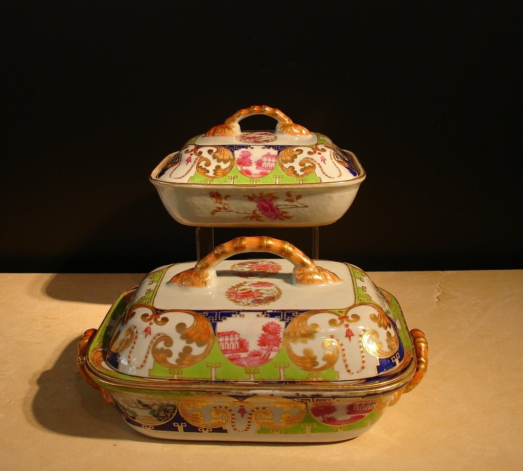 Comprised of one covered vegetable tureen and one larger covered entree tureen with two bamboo-form handles. Both lids also feature bamboo form handles. Together with a rectangular serving dish that doubles as a warming tray. 

All decorated with