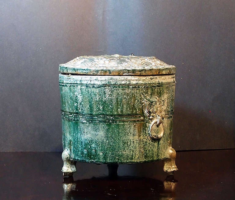 Ein wunderschönes Vorratsgefäß aus der Han-Dynastie (206 v. Chr. - 200 n. Chr.). Der runde Korpus steht auf drei Beinen und ist mit einem Deckel versehen. Die Gesamtheit ist mit einer schweren grünen Bleiglasur überzogen, die Bronze imitiert. An den