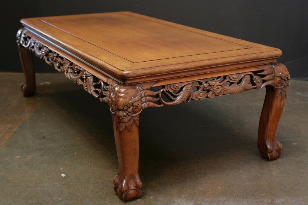 A handsome Chinese carved hardwood coffee table with a design of dragons, Republic Period, early 20th century, circa 1920, China.

The table well-proportioned and well-carved. The top is comprised of a single, solid floating panel. The apron has