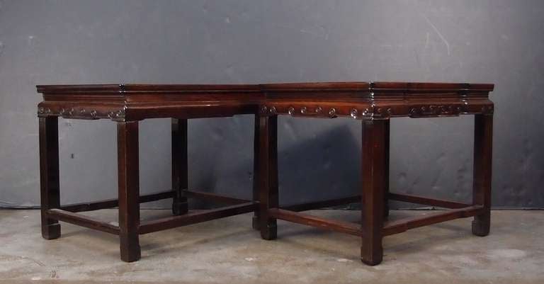 An elegant and attractive pair of Chinese hongmu (rosewood) side tables. The attractively grained centre panels site above a narrow waist and apron decorated with a stylized ruyi pattern. The straight square legs end in horse hoof feet and are