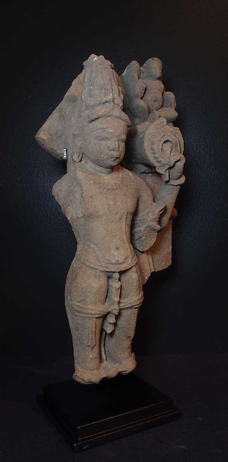 An Indian medieval period buff/red sandstone carving of Vishnu, Madhya Pradesh, circa 10th-11th century.
Although fragmentary, this figures is still identifiable as the god Vishnu by the crown upon his head and the chakra he holds in his upper