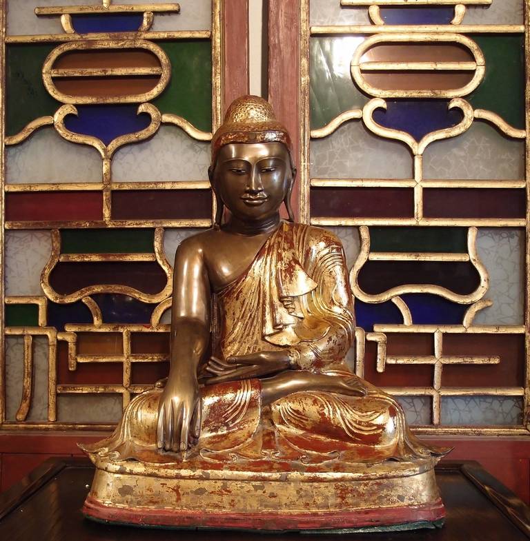 A large, well cast Burmese bronze seated Buddha. 
The historical Buddha, Shakyamuni, is portrayed seated in bhumisparsa mudra, the gesture of calling the Earth to witness, symbolizing the moment of his enlightenment. His face is sweet and serene,
