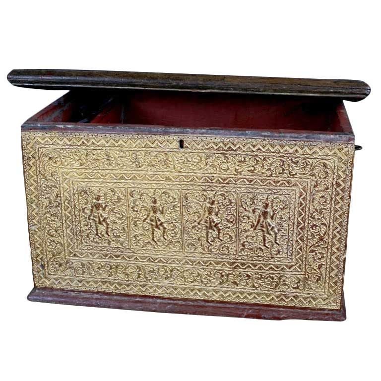 A fine and rare Burmese temple chest, known as a sadaik, made of heavy teak, with carved and molded lacquered decorations, and richly gilt. Originally used to house and protect Buddhist manuscripts. <br />
<br />
Decorated in relief carved and