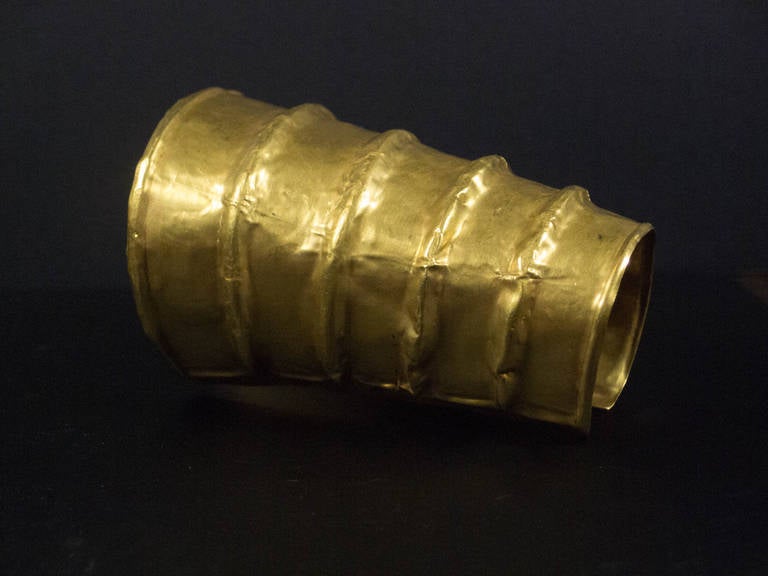 A large and impressive solid high karat gold cuff from the Dian Kingdom, circa 2nd century BC, modern day Yunnan Province, China. 
.
This striking cuff is crafted from hand hammered high karat gold (20-22-karat). Of tapered design, the cuff covers a