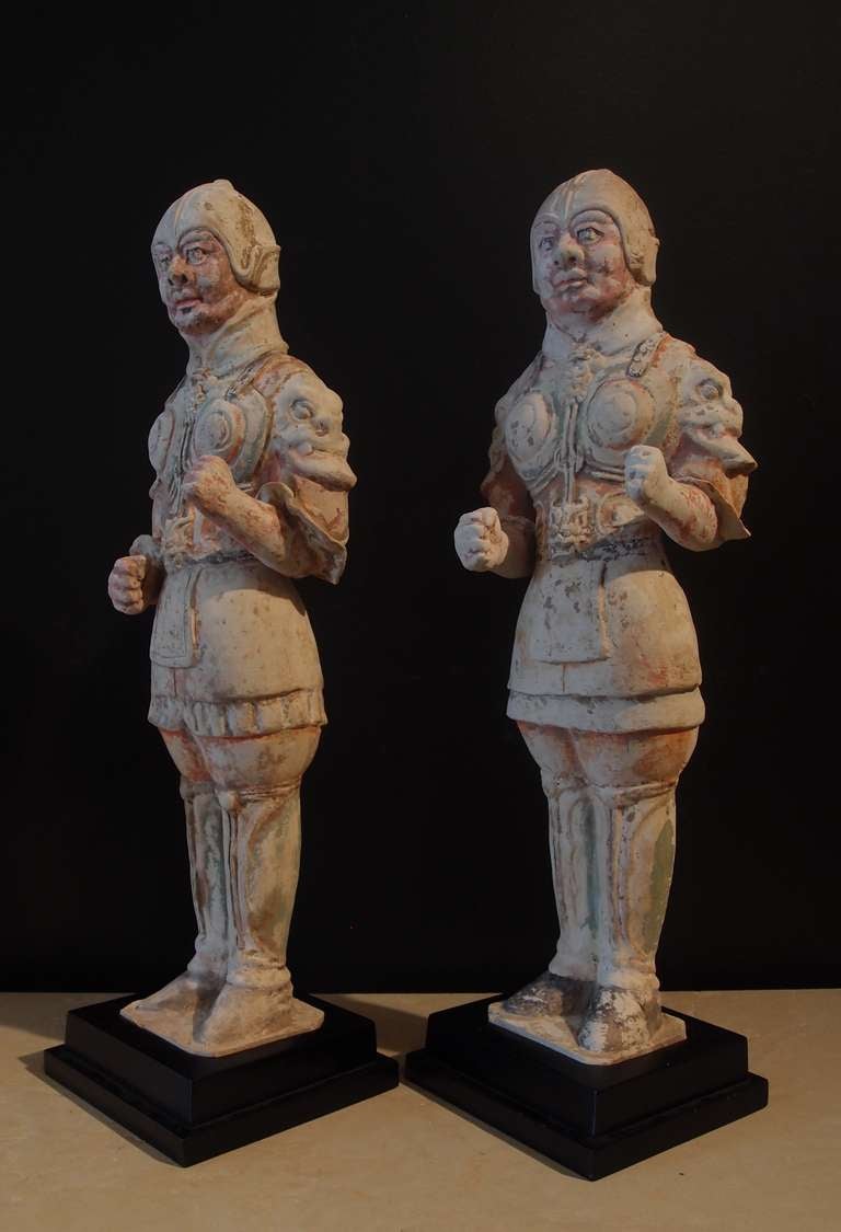 Une paire de soldats en poterie peinte de la dynastie Tang, bien modelés.
Les guerriers sont représentés debout, vêtus d'armures moulantes et élaborées, avec des casques adaptés. Les plastrons présentent d'impressionnants masques de taotie sur les