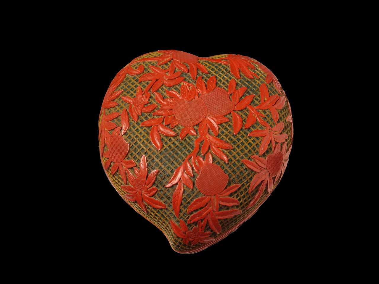 A large and impressive carved three color cinnabar lacquer box in the form of a peach. Both the top of and bottom feature a design of nine peaches, each peach with a different diaper motif. The red layer carved down to reveal the yellow layer,