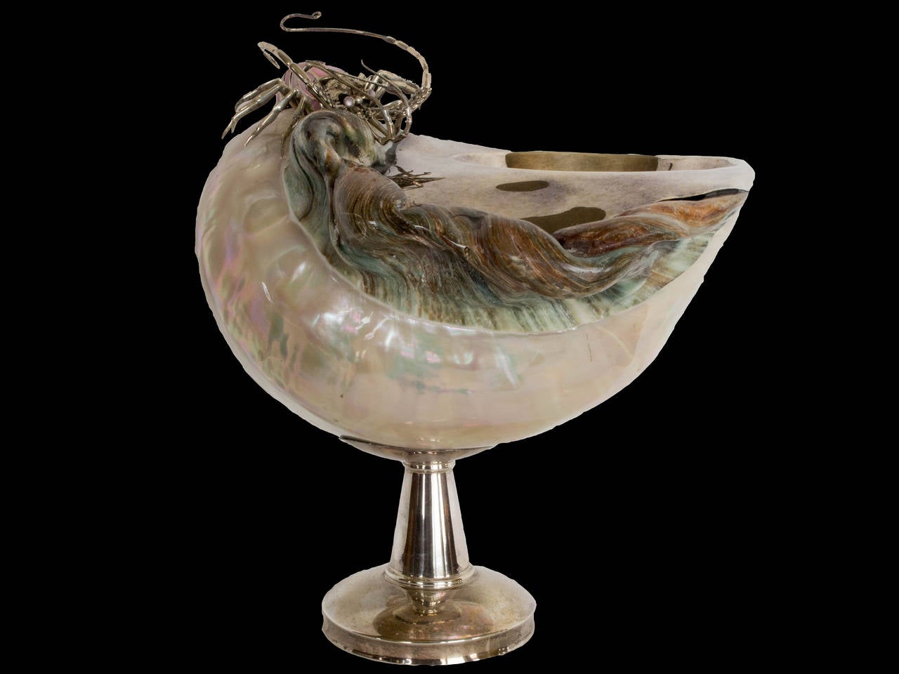 An absolutely gorgeous and magnificent realized shell and sterling silver caviar bowl or dish. Set on a sterling silver pedestal foot, the bowl formed by a large, pearlized natural spiral seashell fitted with a sterling silver lining. 
The shell