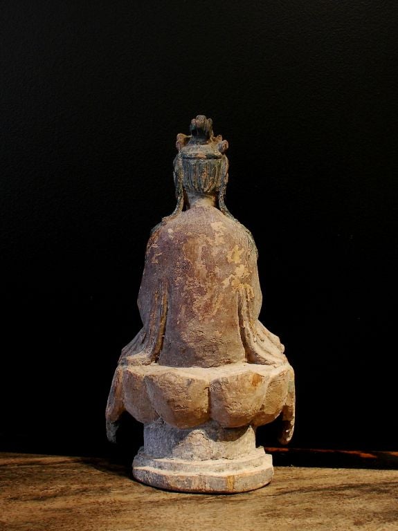 A nicely carved figure of Guanyin, the bodhisattva of compassion. Seated on a raised dais, hands in dhyana mudra (position of meditation or contemplation) holding a small bowl. He is dressed in long flowing robes that drape elegantly around him. A