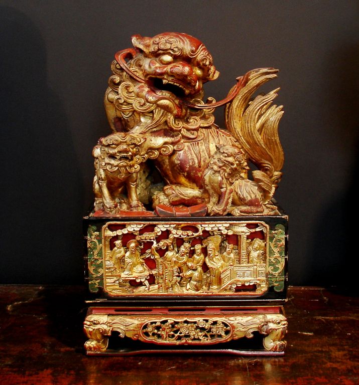 A superbly carved foo lion (aka foo dog) surrounded by two cubs, sitting atop deep relief carved panels of immortals. The pedestal features wonderfully whimsical lion faces and feet. Originally used as a temple incense box.