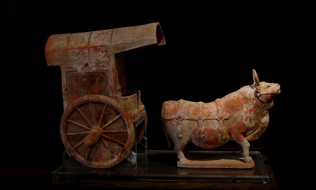 A fine pottery model of an ox and cart. Realistically molded, the ox displays Fine musculature and elements of a harness system. With one fore and one rear leg bent, he conveys a sense of eternal motion. A wooden yoke would originally have been part