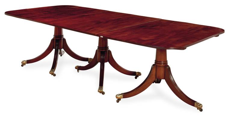 AN ENGLISH MAHOGANY TRIPLE PEDESTAL DINING TABLE
20TH CENTURY, with two leaves 
29in. (73.7cm.) high, 107in. (271.7cm.) wide, 48in. (121.9cm.) deep