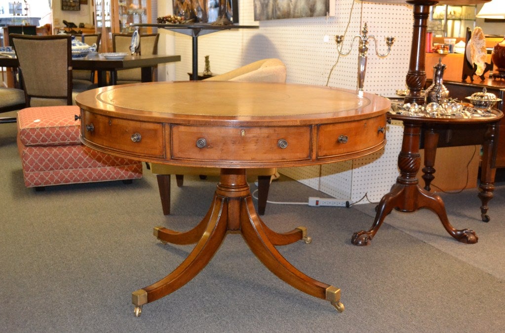 This handsome table is made of yewwood. It has eight drawers, four of which are working drawers. The top is covered in tan tooled leather.