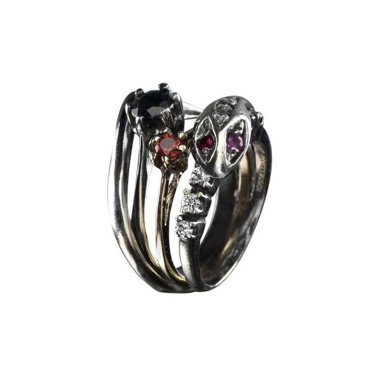 Inspired by the traditional love of Italian women to be adorned by their stories made of love and memories, this stacked ring is designed with a snake’s head small band swirled around two solitaire rings. The solitaire ring with red zircon is in