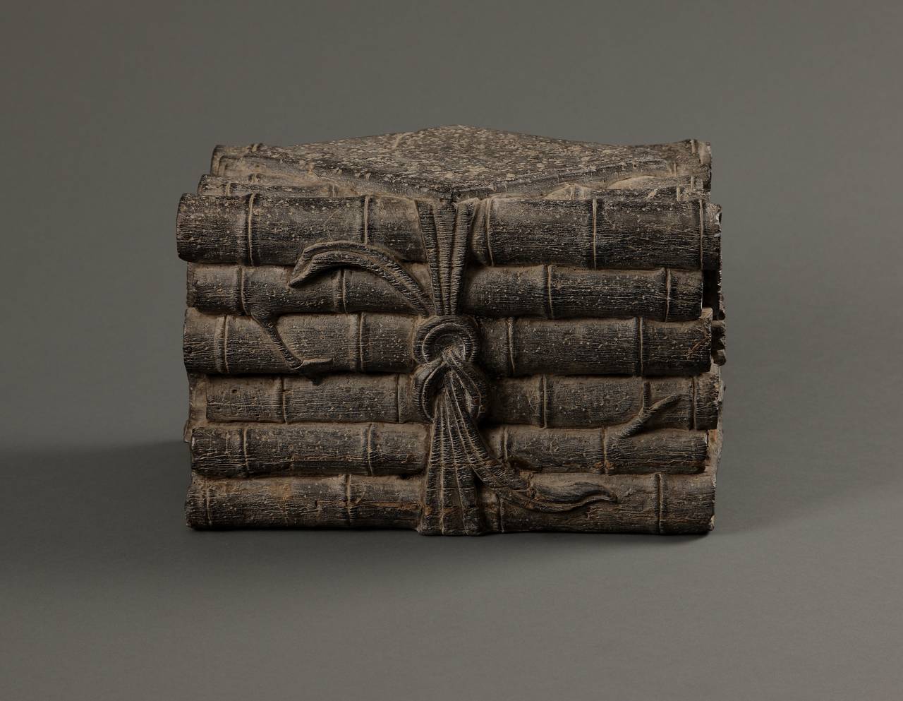 A pair of black stone sculptures carved to depict a Chinese bookshelf of scrolls.