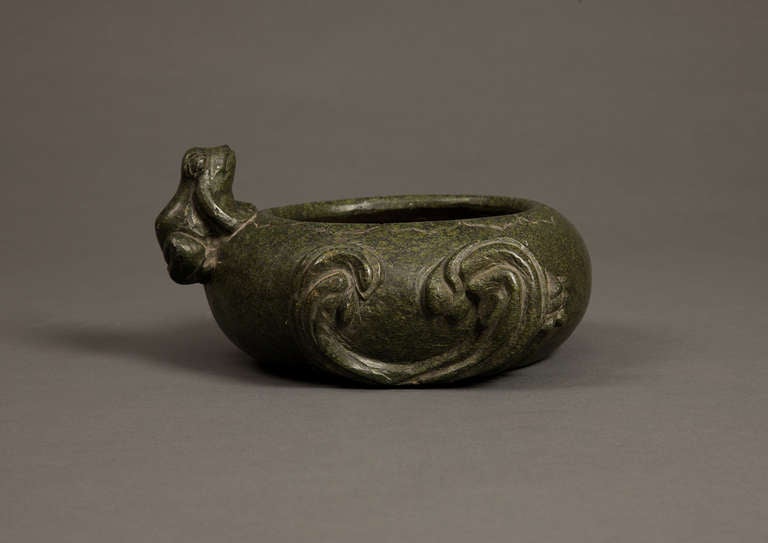 A 19th century decorative bowl carved from stone with frog and wave motifs. This green patinated bowl was crafted in China.