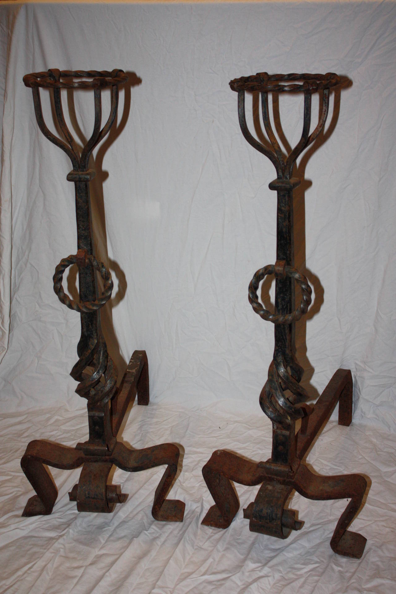 This is a really nice pair of wrought iron andirons I purchased in France.  They are very large in size.  The iron work is exceptional.  The baskets atop each andiron were used in cooking but are very attractive on their own or holding a flower