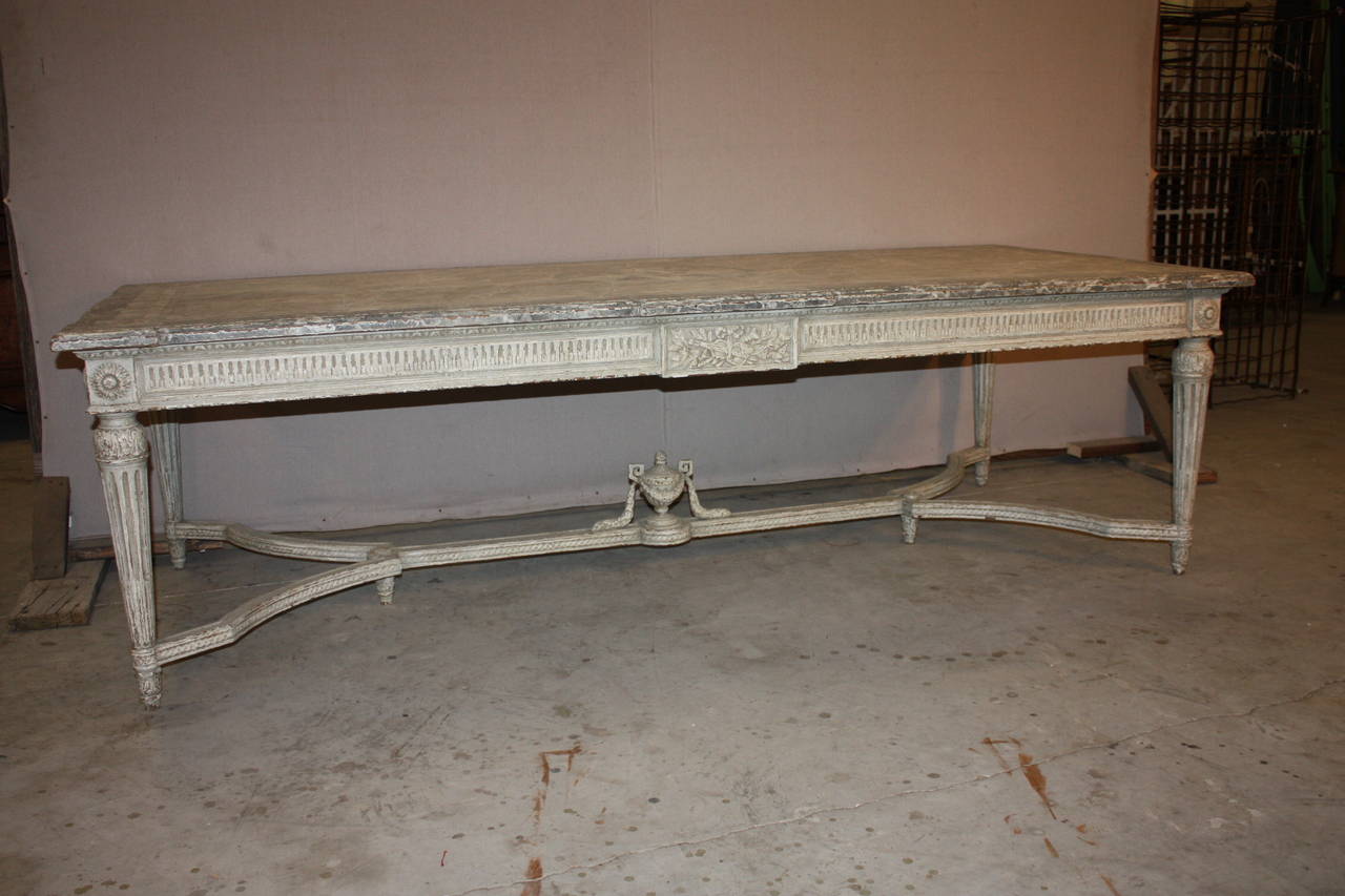 This is a really beautiful French dinning room table with a faux marble top.  It is in great shape.  There is a central design on the top that somewhat resembles a  compass rose.  The carvings on the base are exceptional.