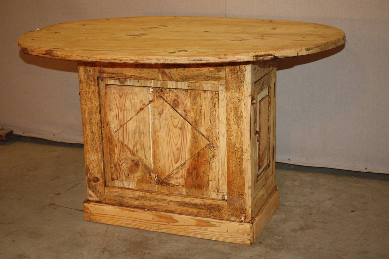 This is a very unique French wine table that dates to the late 1800s. Most wine tables are open below. This sits upon a small cabinet with doors on each side accessing compartments to store wine. There is also a drawer on one side. The top not only