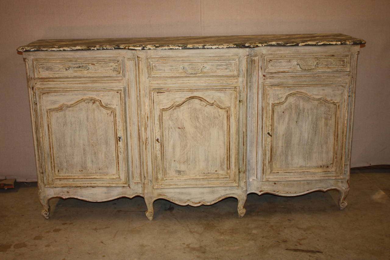 This is a very nice looking painted French enfilade from the early 1900s. It has a faux marble-top. It has three compartments each with its own door. Each compartment has a shelf. There are also three drawers.