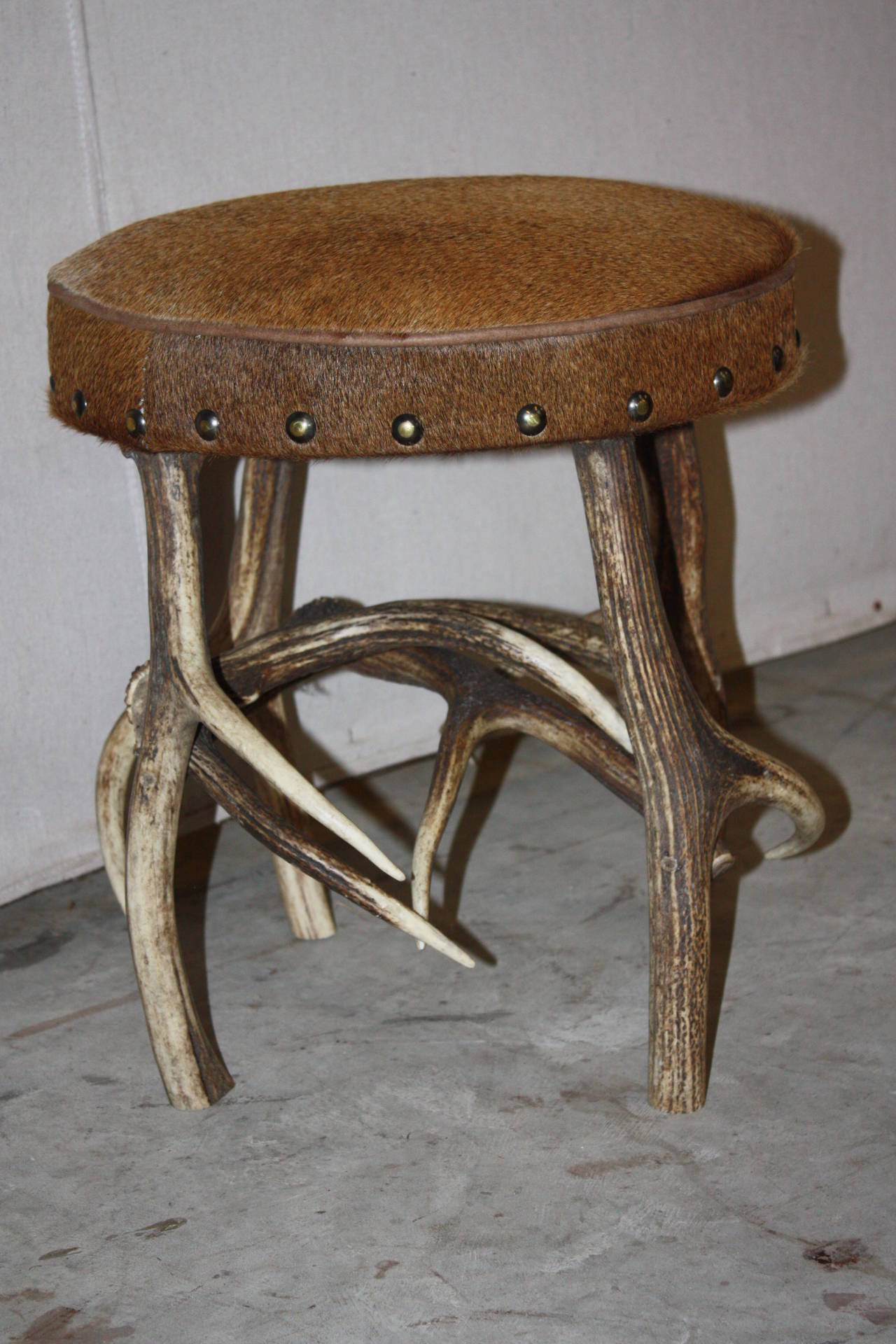 This is a very nice looking stag horn based stool that is upholstered with a hair on hide.  The stool is very well put together.  I purchased it in England.  I actually have 4 different stools with similar bases but each upholstered with hides of
