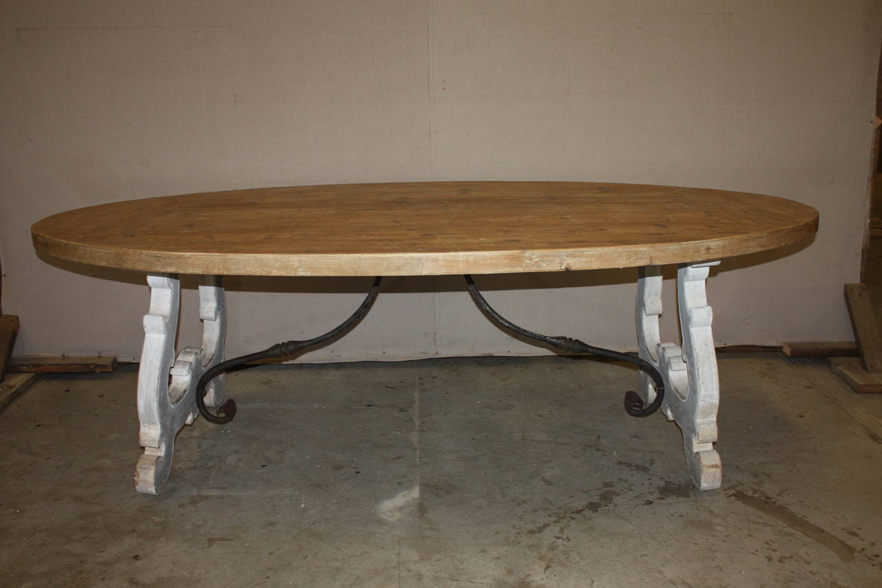 This is a very attractive Italian oval trestle table with a washed pine top and a painted base. It dates to the early 1900s. It sits up to eight.