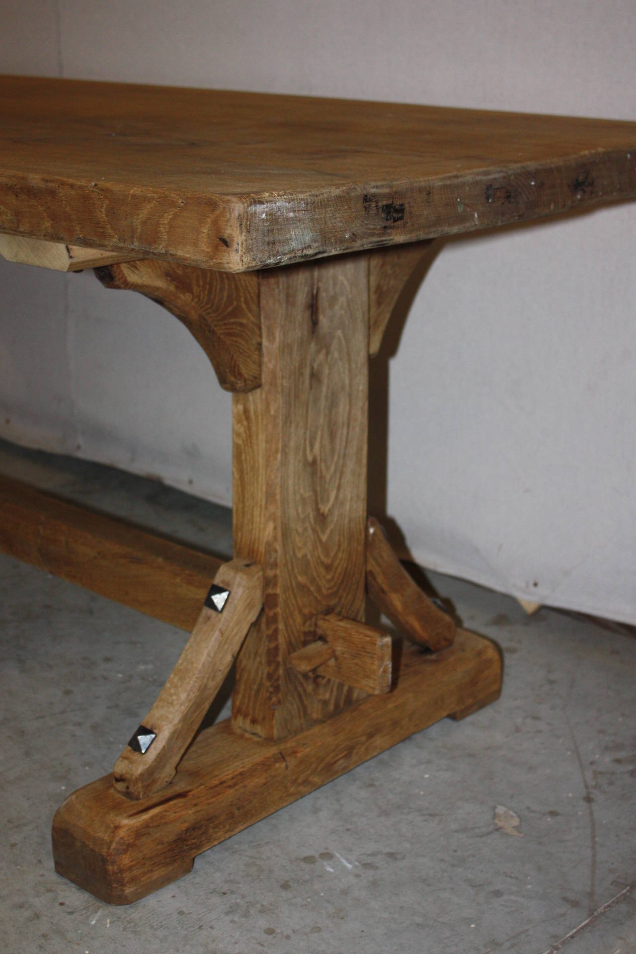 This is a great looking 19th century French oak trestle dining table. It has a beached or washed look to it. The grain of the wood is very nice and aged. The design of the tables base is very attractive.