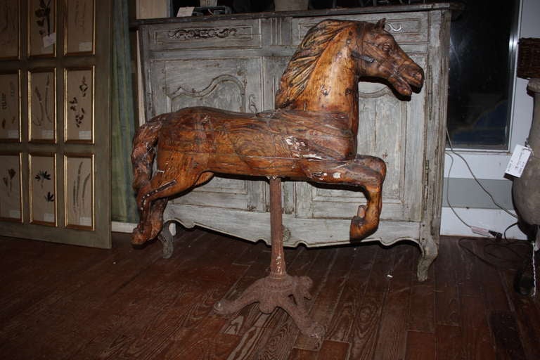 This is a really nice large hand carved wood, French merry-go-round horse from the 18th century.  It has a cast iron stand that goes very well with it.  The horse was very nicely carved.  There are some metal braces on it that were probably original