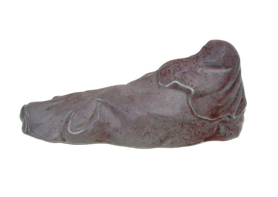 A Chinese peachbloom glazed recumbent figure