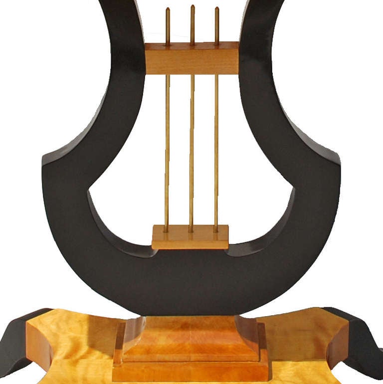 Table top with a drawer on a black polished lyre standing on a base with curved black polished feet.