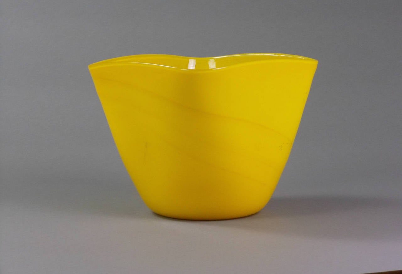 This striking Murano vase is made of thin bright yellow glass with streaks of gold. The base shows three acid stamps of "Made in Italy" and an unidentified artist cipher.