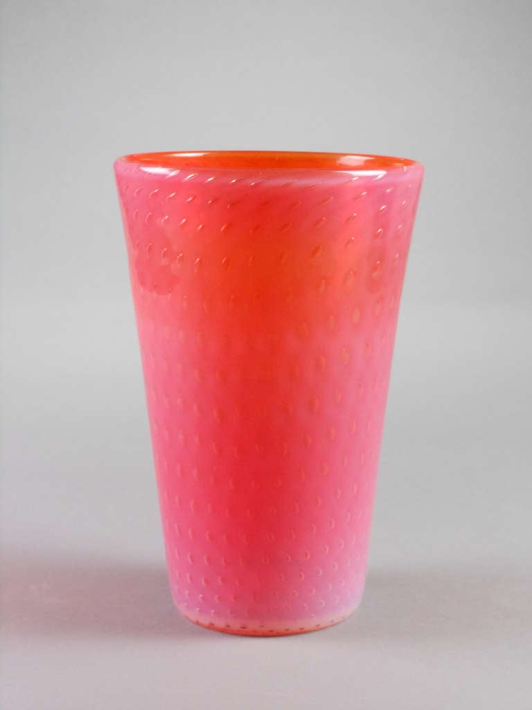 The Finnish pink and orange glass vase is of circular tapering form with concentric rings of bubbles. Signed 30-6-44-GN.

Gunnel Nyman was a glass designer at Nuutajarvi Glassworks, Finland. She experimented with trapped bubbles in glass creating