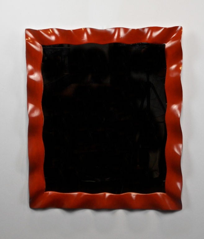 A French Red Lacquer Wave Molded Mirror
