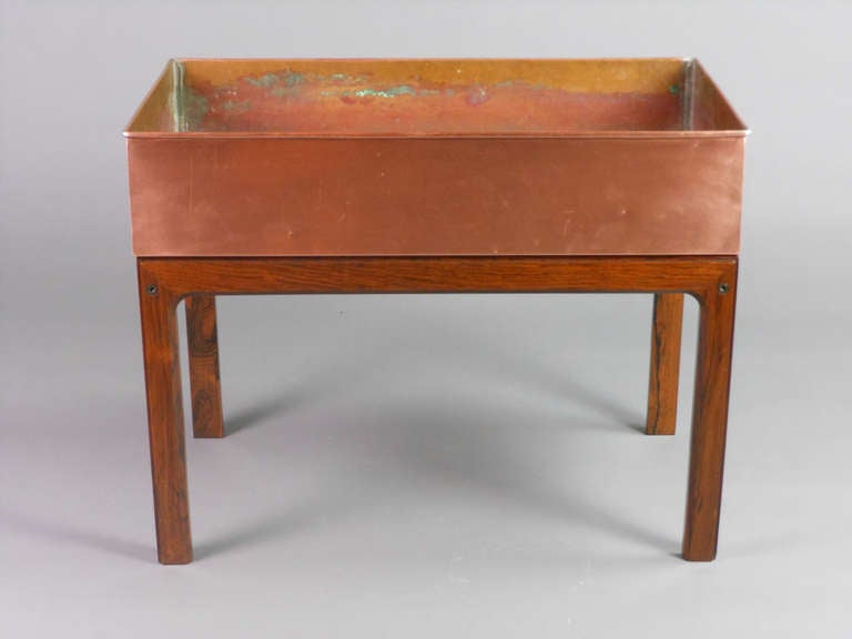 The rectangular copper planter sits on a conforming wooden stand. Stamped Made in Denmark.