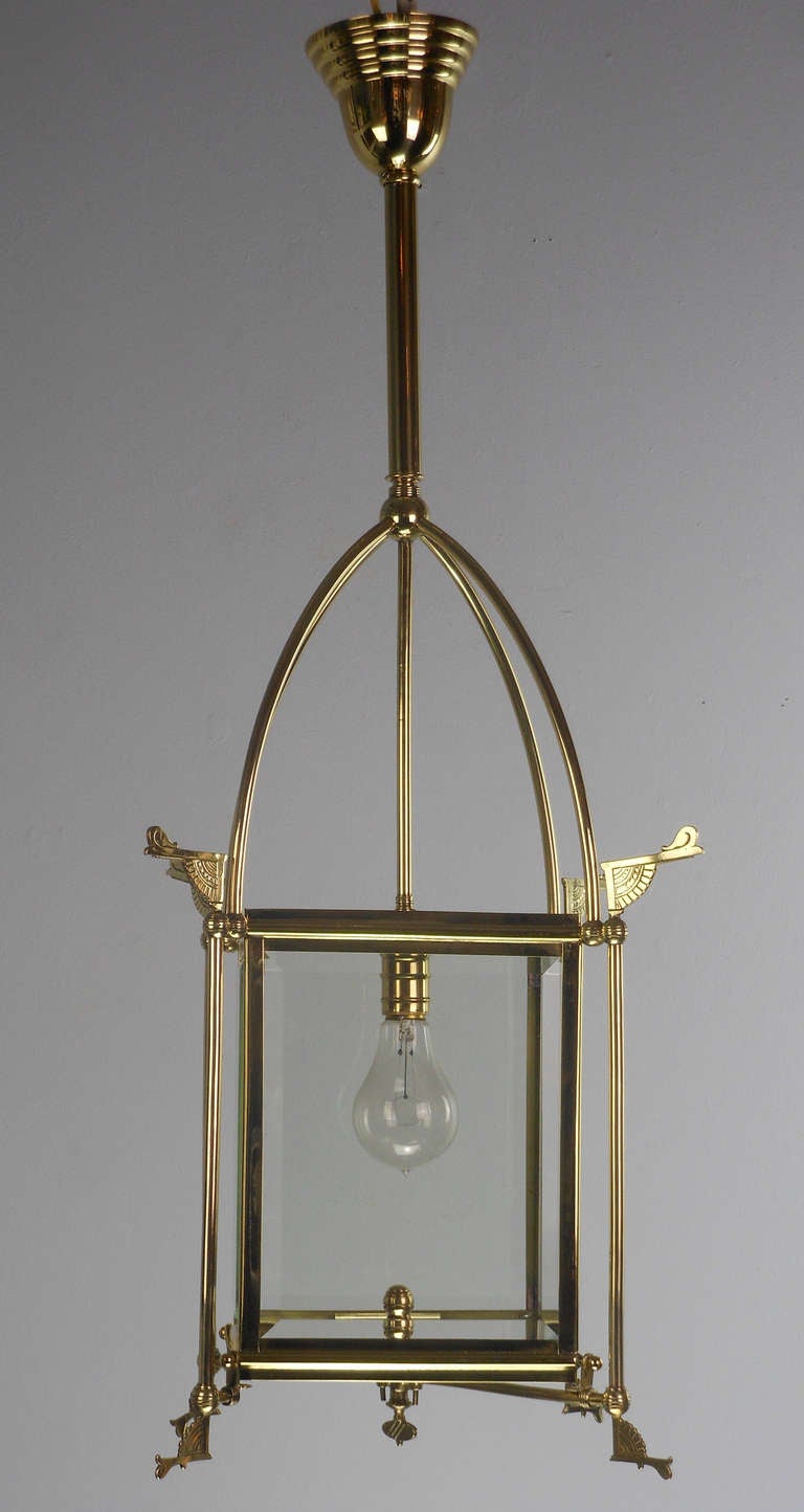 The rectangular sides with beveled glass panels fitted to a frame with fan brackets and scroll finials, surmounted with an open arch.  Originally fitted for gas.